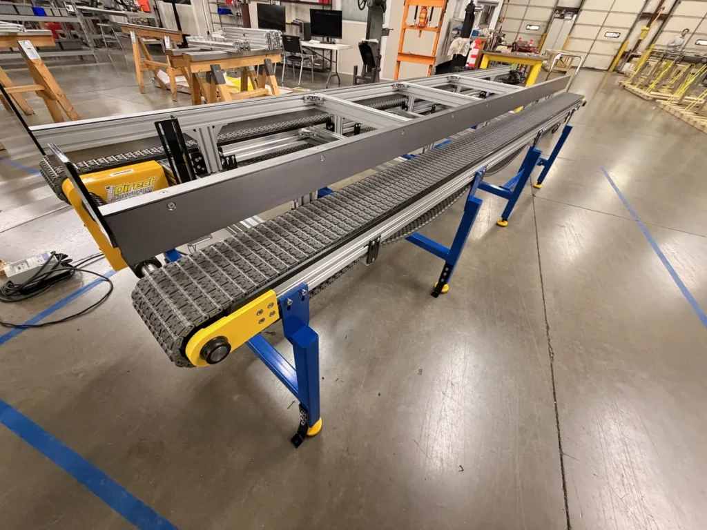 Full-length side view of dual lane modular plastic belt conveyor with high-friction belting and blue tubular steel legs