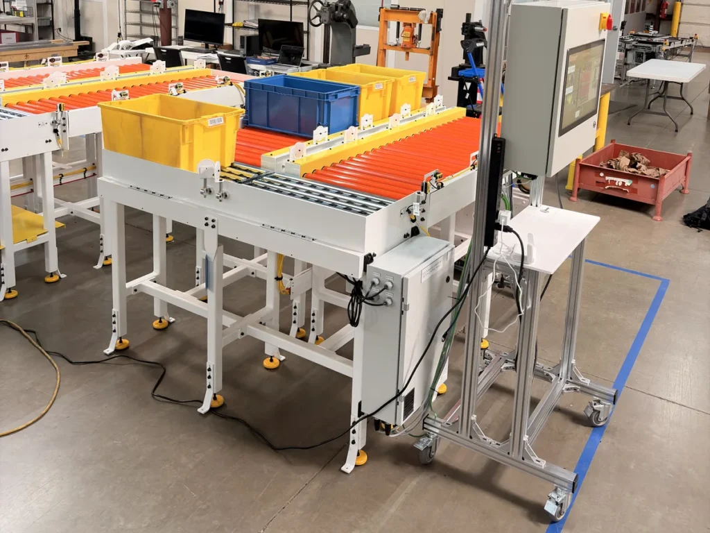 Tote conveyor cell with soft PLC test panel and touchscreen used for IO checks during factory acceptance testing